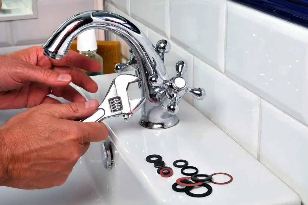 Plumber performing maintenance on a bathroom faucet in Stuart