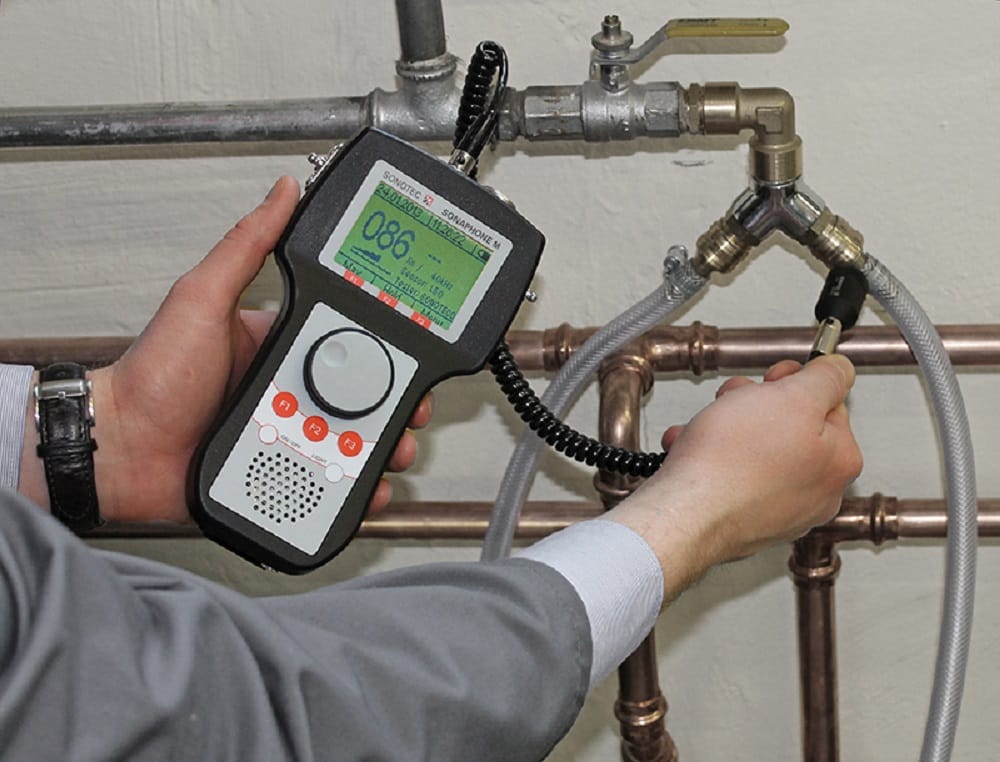 Plumber testing pipes with electronic leak detection equipment in Stuart