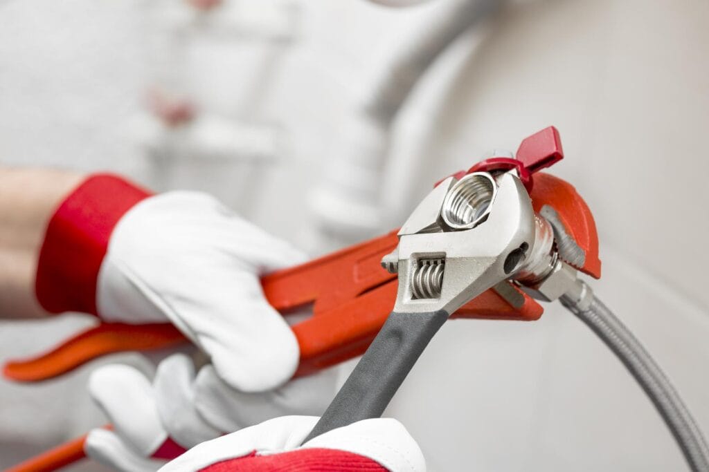 Plumber holding pipe wrenches for an emergency repair in Stuart