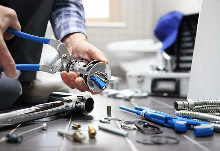 Technician repairing a plumbing fixture with professional tools in Stuart