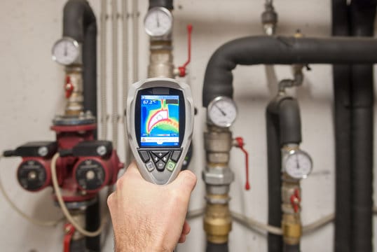 Plumber using a thermal imaging camera to inspect pipes in Stuart