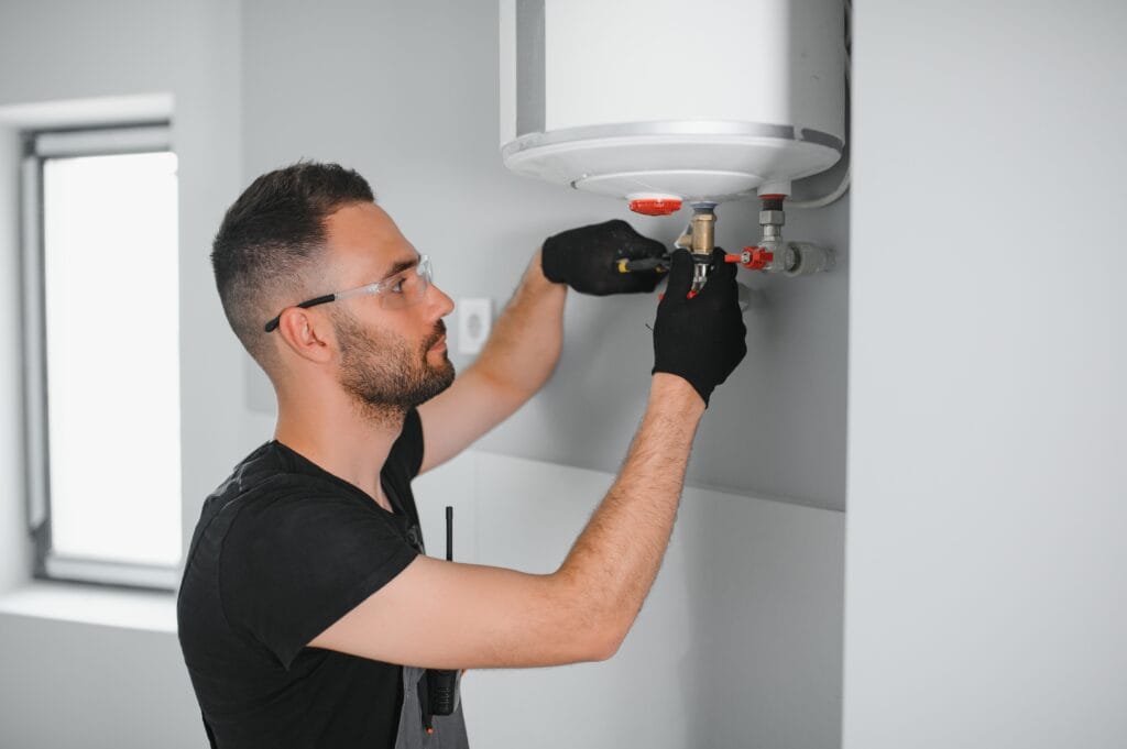 Technician performing water heater maintenance in Stuart