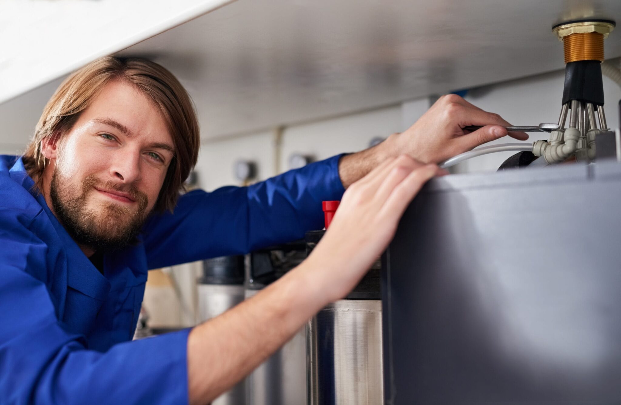 Technician servicing a residential water heater tank in Stuart