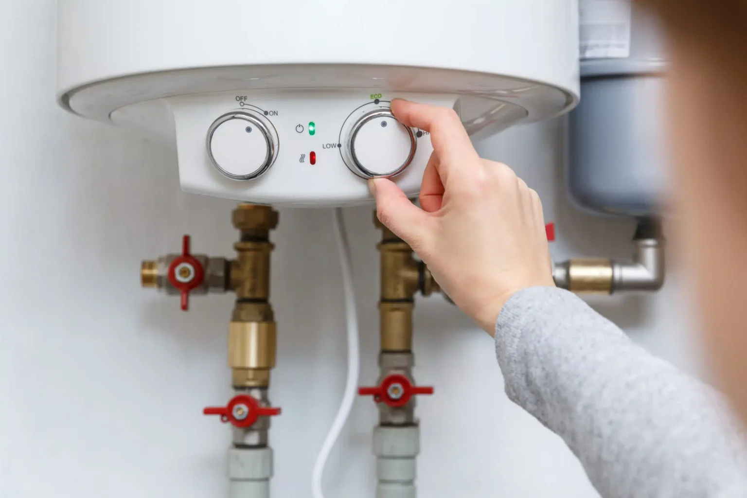 Homeowner adjusting the temperature controls on a water heater in Stuart