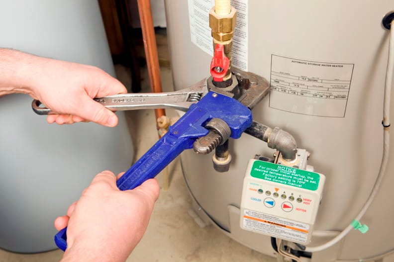 Plumber repairing a water heater valve in Stuart
